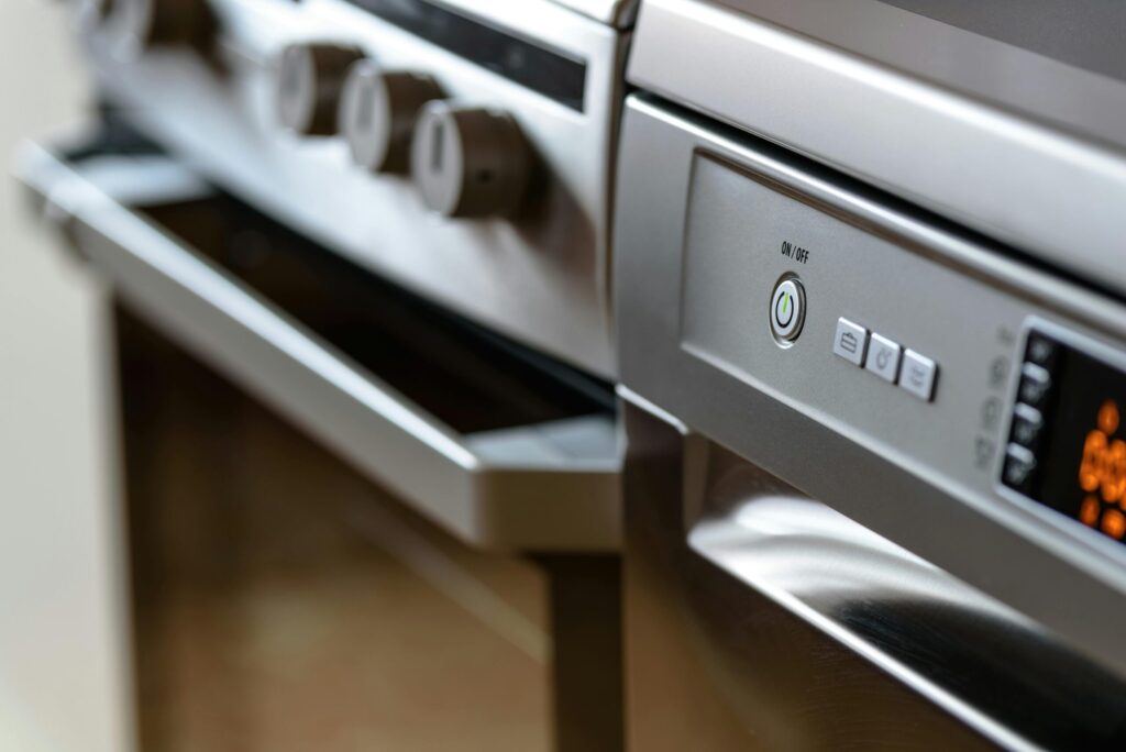 Close-up of a modern stainless steel oven and dishwasher.